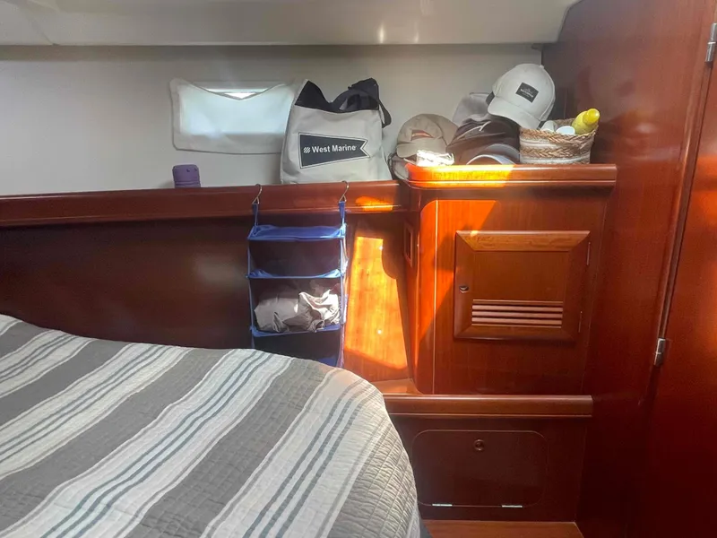 Slide: The Image of Interior cabin of 2004 Beneteau Oceanis 473 yacht with wooden cabinetry and striped bedding. - 27