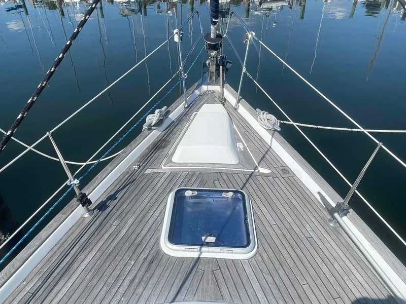 Slide: The Image of 2004 Beneteau Oceanis 473 sailboat deck with hatch, docked on calm water. - 29