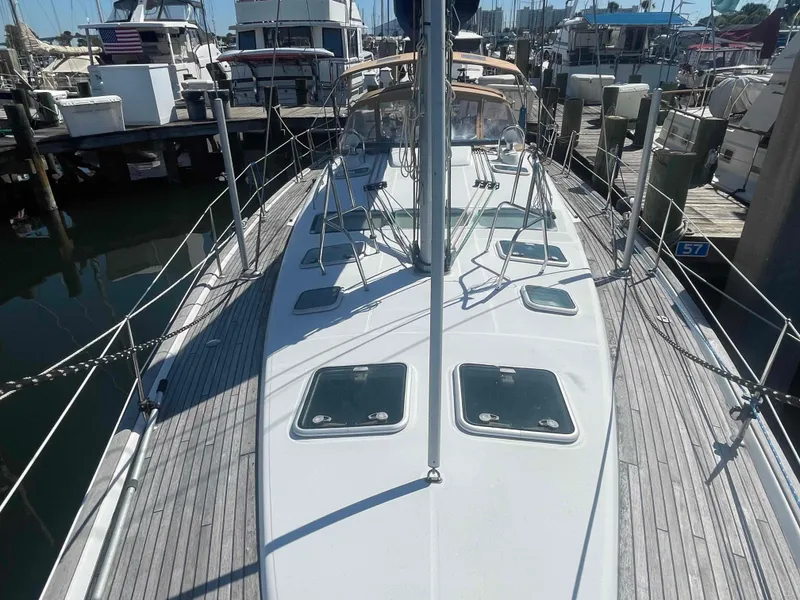 Slide: The Image of 2004 Beneteau Oceanis 473 sailboat docked at marina, showcasing deck and hatches. - 31