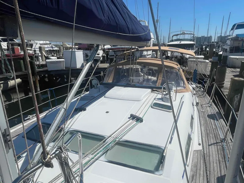 Slide: The Image of 2004 Beneteau Oceanis 473 sailboat docked at a marina, showcasing deck and rigging. - 32