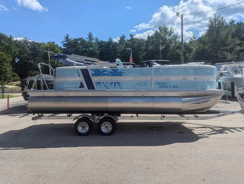 Slide: The Image of 2025 Berkshire 22E CTS pontoon boat on trailer, parked outdoors under a clear sky. - 2