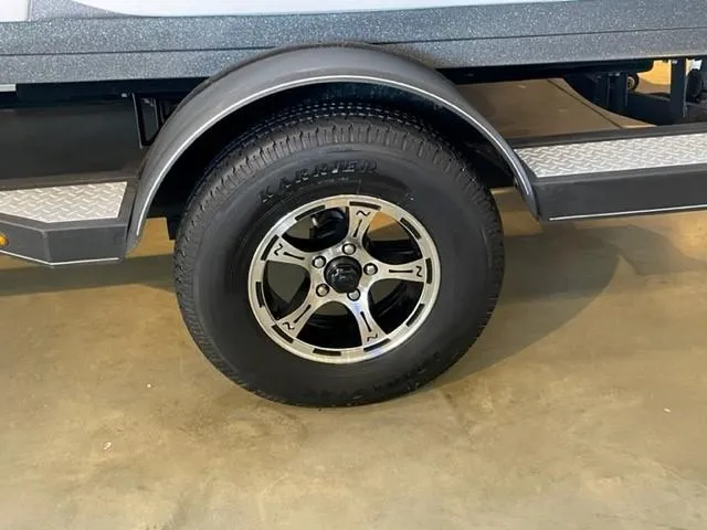 Slide: The Image of 2019 Nitro Z19 Sport trailer wheel with black tire and silver rim. - 9