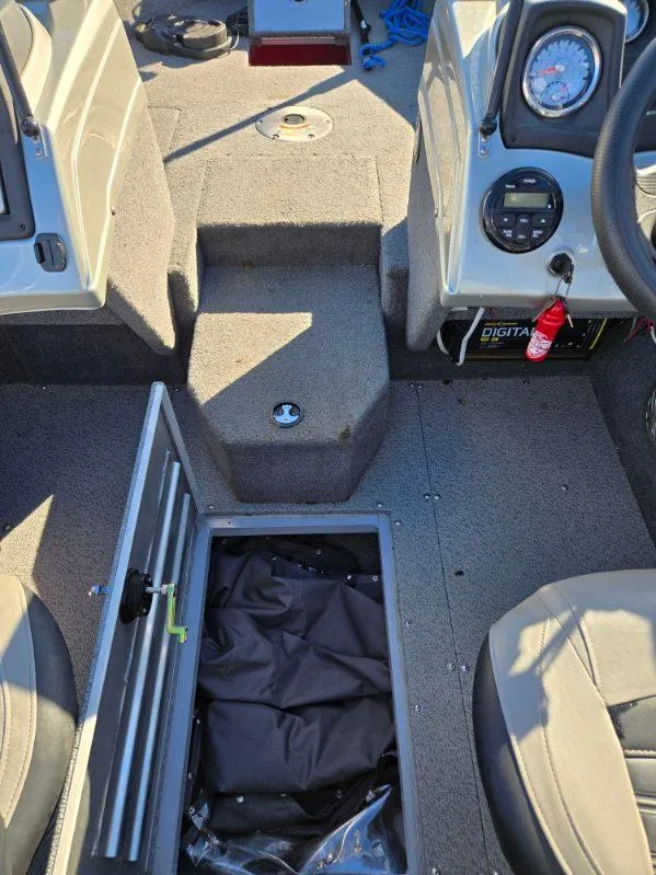 Slide: The Image of 2018 Tracker Pro Guide V-175 WT boat interior with open storage compartment and dashboard controls. - 13
