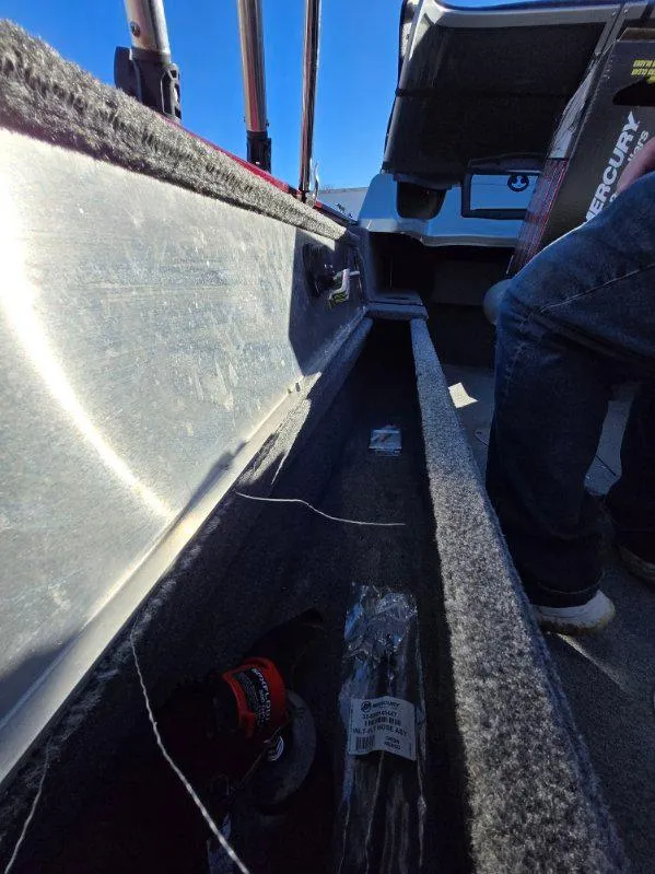 Slide: The Image of 2018 Tracker Pro Guide V-175 WT boat interior with storage compartment and fishing gear. - 21