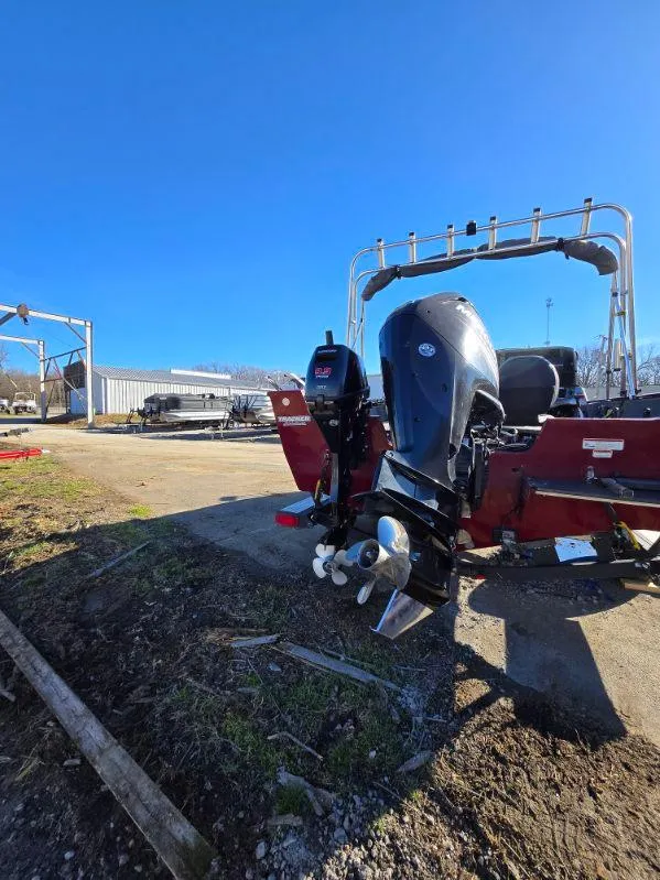 Slide: The Image of 2018 Tracker Pro Guide V-175 WT boat with outboard motor, parked outdoors. - 23