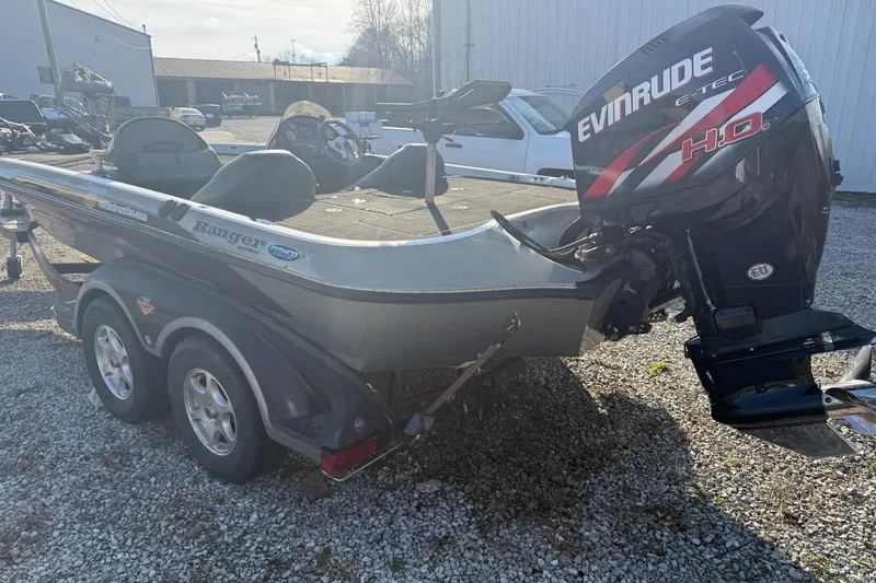 Slide: The Image of 2003 Ranger 521DVX boat with Evinrude motor, parked on gravel. - 4