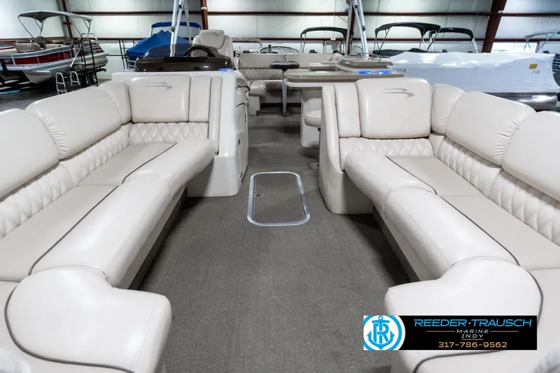 Slide: The Image of 2014 Bennington 2250 RCB pontoon boat interior with beige seating in showroom. - 16