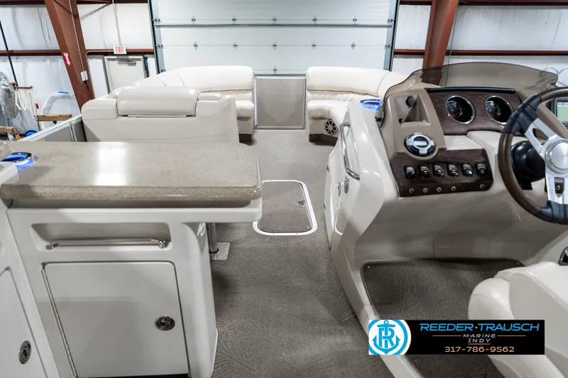 Slide: The Image of 2014 Bennington 2250 RCB boat interior with steering console and seating in a garage. - 20