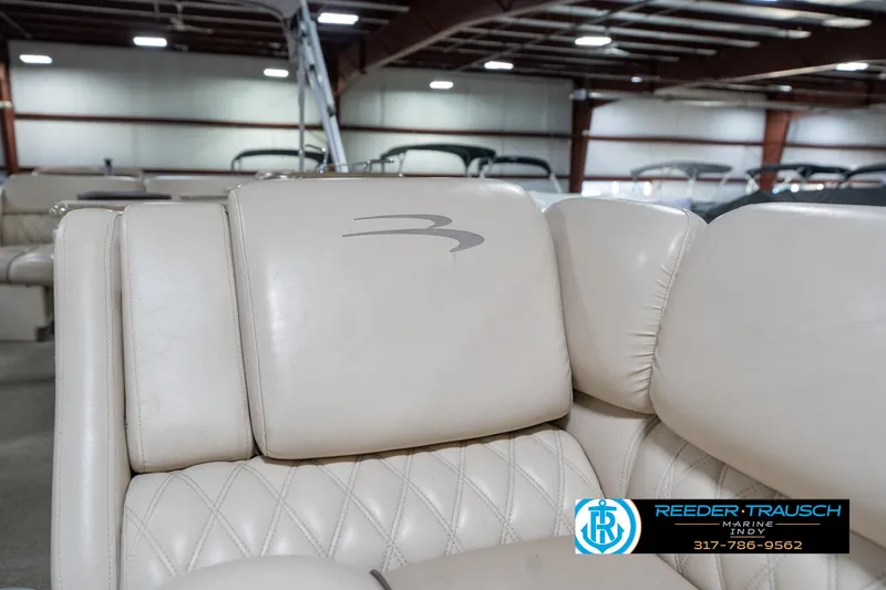 Slide: The Image of 2014 Bennington 2250 RCB boat interior with beige leather seating in showroom. - 23