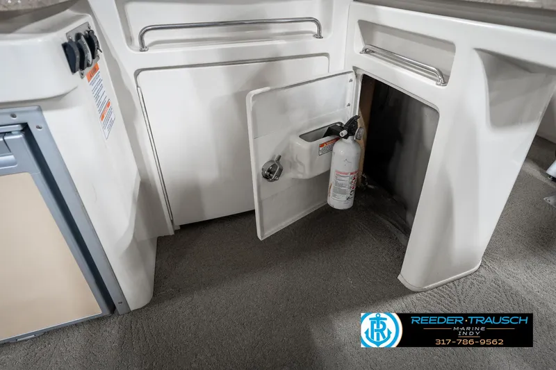 Slide: The Image of 2014 Bennington 2250 RCB boat interior with open storage compartment and fire extinguisher. - 27