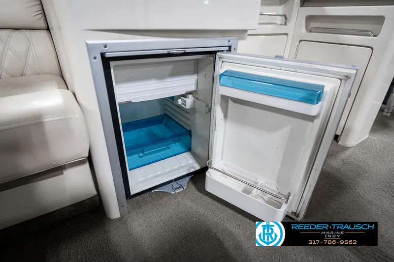 Slide: The Image of Open mini fridge inside 2014 Bennington 2250 RCB boat, featuring blue interior accents. - 29