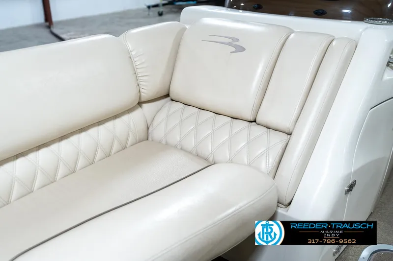 Slide: The Image of Beige leather seating on 2014 Bennington 2250 RCB boat, featuring diamond stitching and logo. - 43