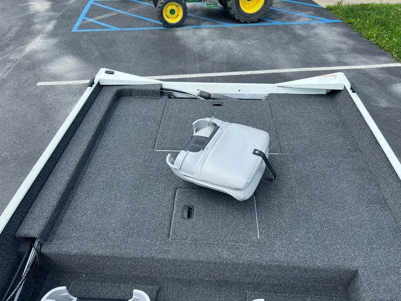 Slide: The Image of 2024 Crestliner 1700 Storm boat deck with a gray seat on a parking lot. - 11