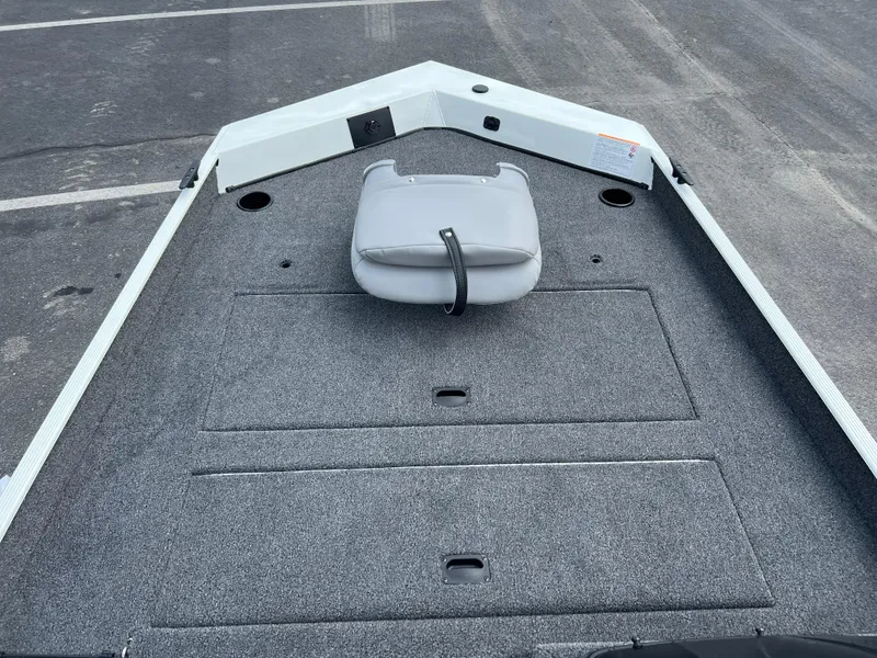 Slide: The Image of 2024 Crestliner 1700 Storm boat deck with gray carpeting and a foldable seat. - 8