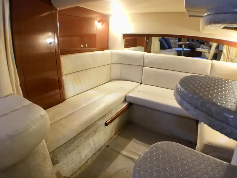 Slide: The Image of Interior of 2002 Sea Ray 320 Sundancer with plush seating and wooden cabinetry. - 17