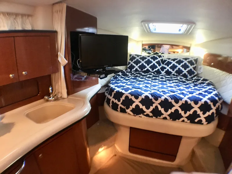 Slide: The Image of Luxurious interior of 2002 Sea Ray 320 Sundancer with bed, TV, and sink. - 21