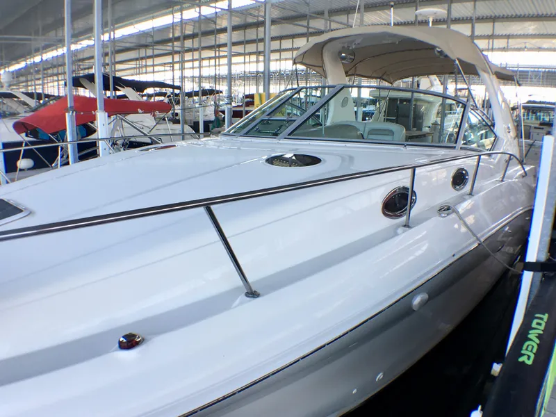 Slide: The Image of 2002 Sea Ray 320 Sundancer boat docked in a marina under a covered area. - 5