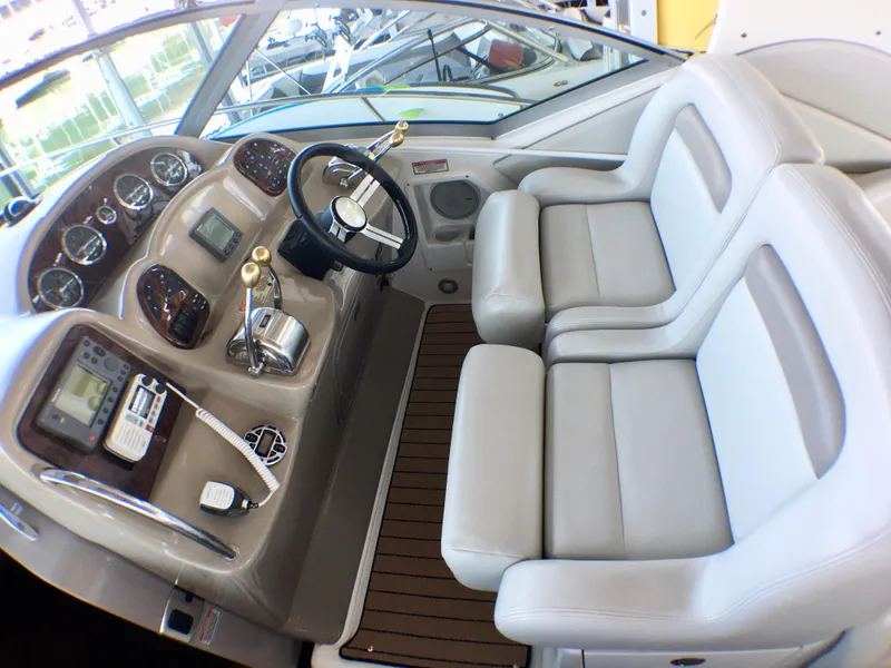 Slide: The Image of 2002 Sea Ray 320 Sundancer cockpit with dual seats and modern controls. - 8