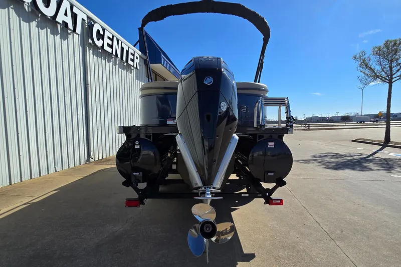 Slide: The Image of 2023 Regency 250 LE3 pontoon boat at dealership, rear view with outboard motor. - 3
