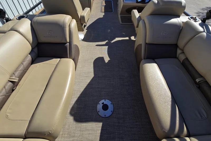 Slide: The Image of 2023 Regency 250 LE3 boat interior with tan leather seating and carpeted flooring. - 4
