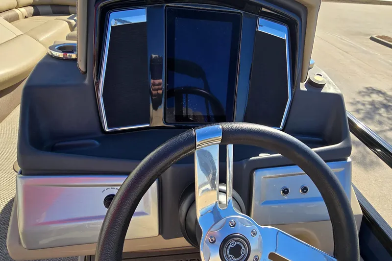 Slide: The Image of 2023 Regency 250 LE3 boat dashboard with steering wheel and control panel. - 5
