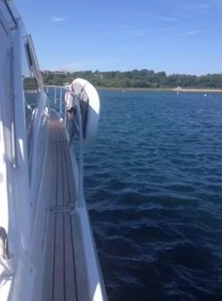 Slide: The Image of 2007 Windy Typhoon 43 yacht on calm waters near a forested shoreline. - 18