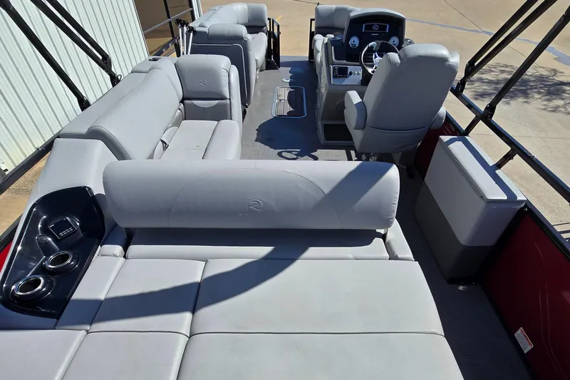 Slide: The Image of 2023 Regency 250 DL3 pontoon boat interior with gray seating and modern helm. - 5