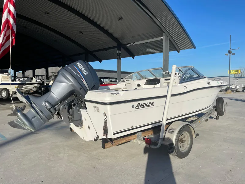 Slide: The Image of 2002 Angler 18 DC boat with Yamaha outboard motor on trailer, parked outdoors. - 3