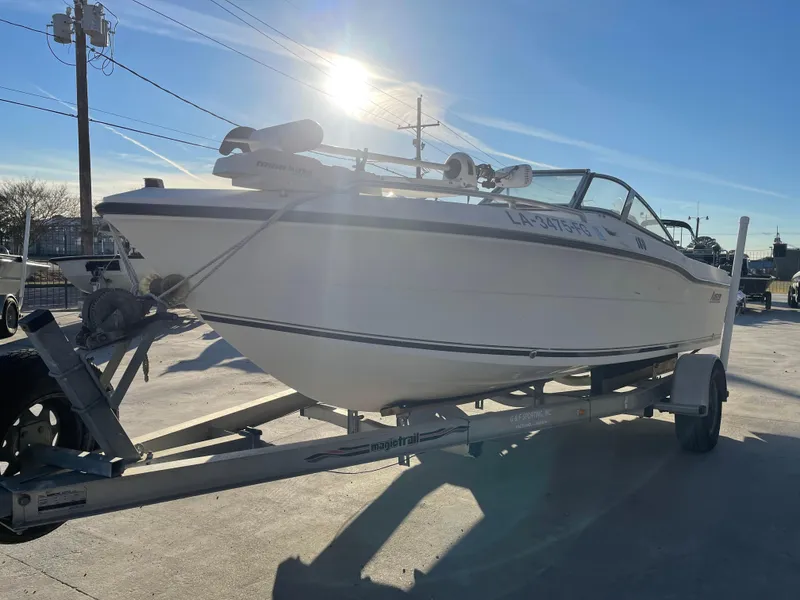 Slide: The Image of 2002 Angler 18 DC boat on trailer, sunlit, parked outdoors. - 5