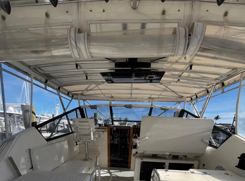 Slide: The Image of 1990 Rampage 36 Sportfisherman boat interior with seating and helm, under a canopy. - 11