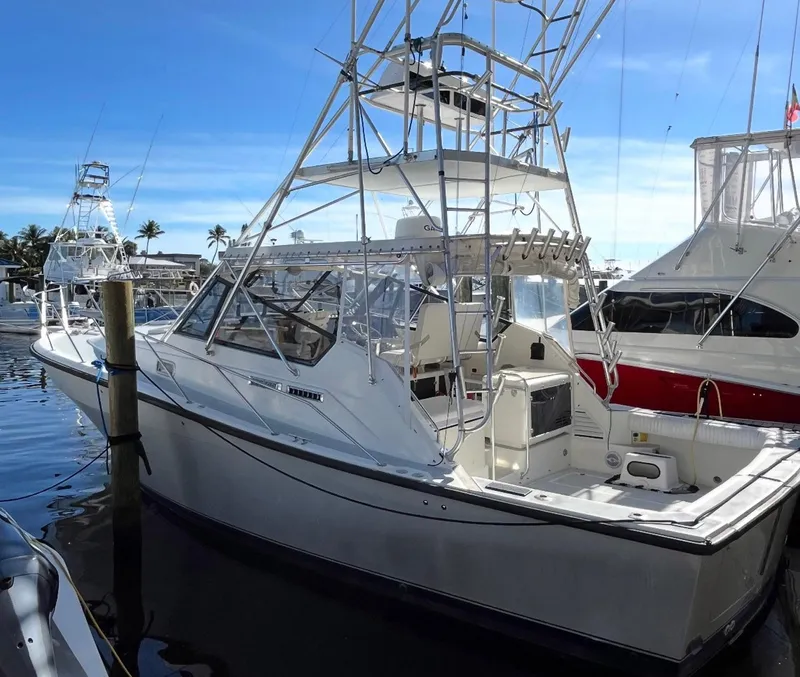 Slide: The Image of 1990 Rampage 36 Sportfisherman boat docked at marina under clear blue sky. - 17