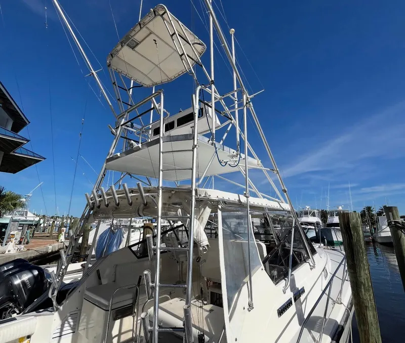 Slide: The Image of 1990 Rampage 36 Sportfisherman boat with tower, docked under clear blue sky. - 5