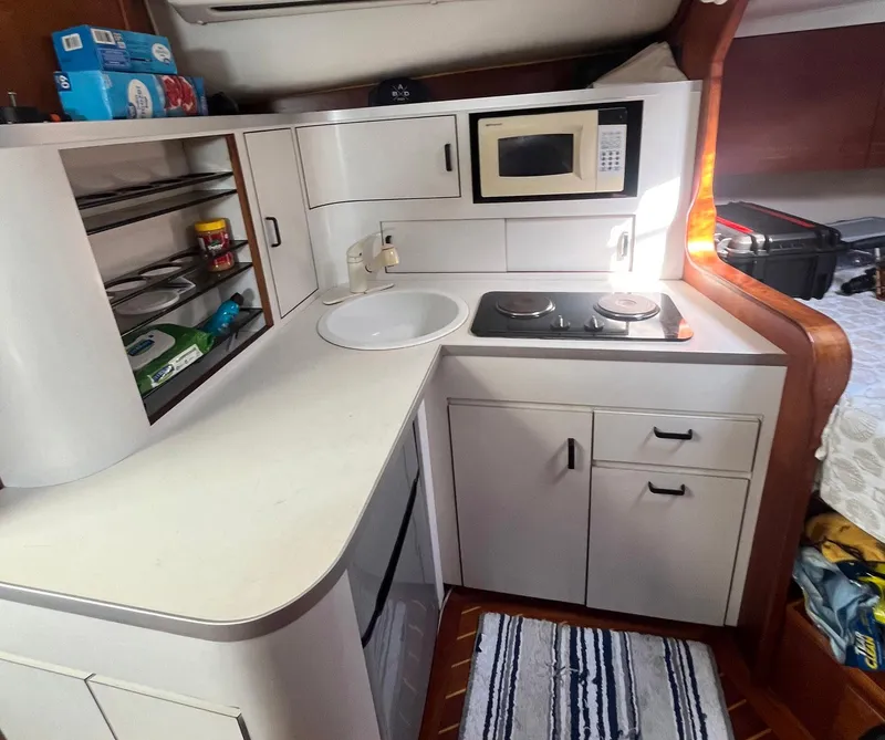 Slide: The Image of 1990 Rampage 36 Sportfisherman kitchen with stove, microwave, and storage cabinets. - 7