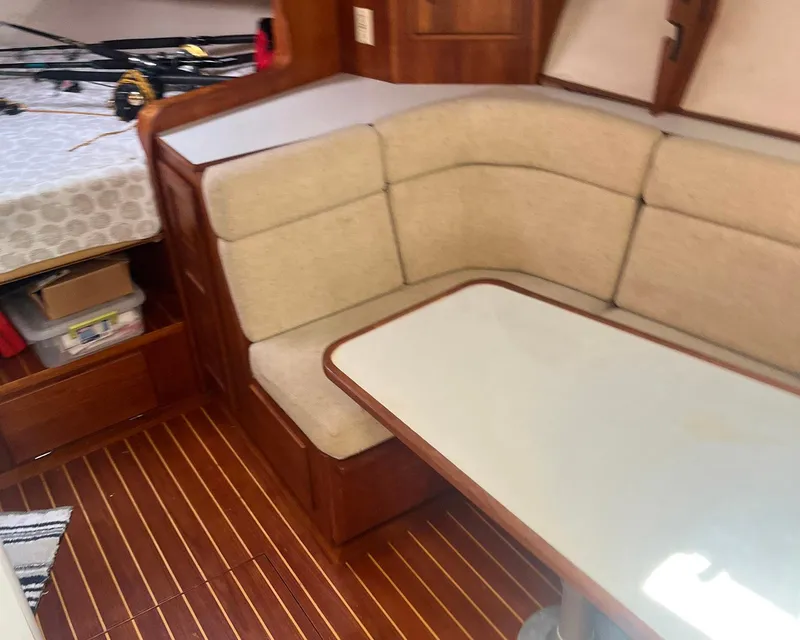 Slide: The Image of 1990 Rampage 36 Sportfisherman interior with beige seating and wooden flooring. - 9