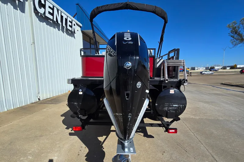 Slide: The Image of 2023 Regency 250 DL3 pontoon boat with powerful outboard motor, parked at a dealership. - 3