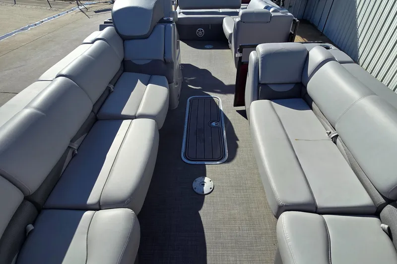 Slide: The Image of 2023 Regency 250 DL3 pontoon boat interior with spacious gray seating. - 5