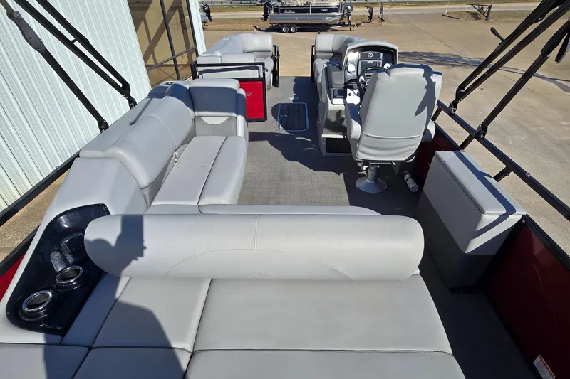 Slide: The Image of 2023 Regency 250 DL3 pontoon boat interior with gray seating and steering console. - 6