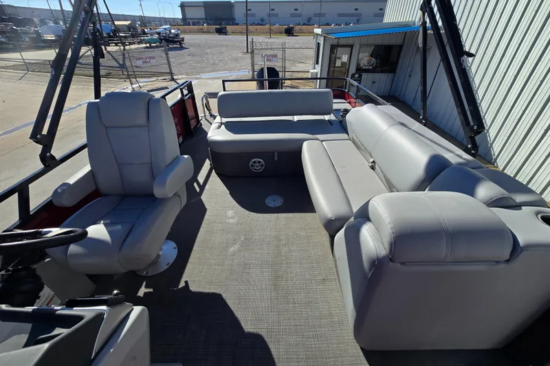 Slide: The Image of 2023 Regency 250 DL3 pontoon boat interior with gray seating and spacious layout. - 7