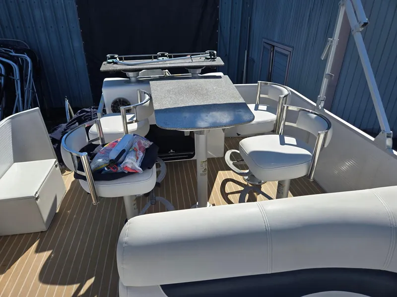 Slide: The Image of 2016 AquaPatio 240 CB boat interior with seating and table setup. - 17