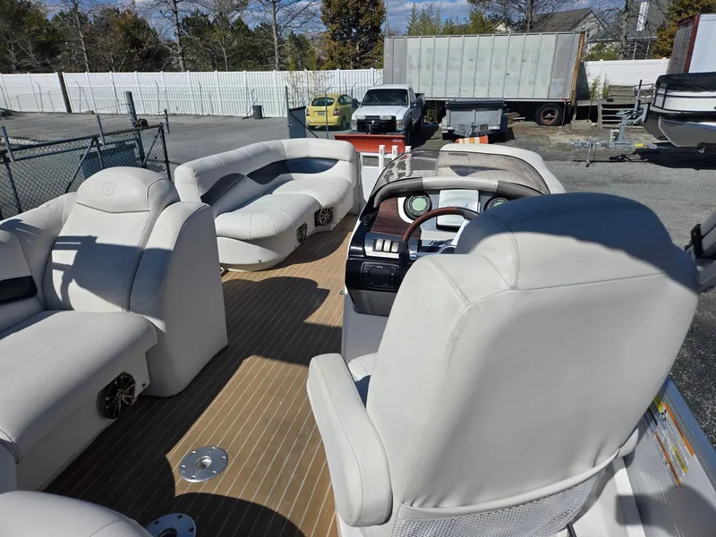 Slide: The Image of 2016 AquaPatio 240 CB boat interior with plush seating and steering console. - 21
