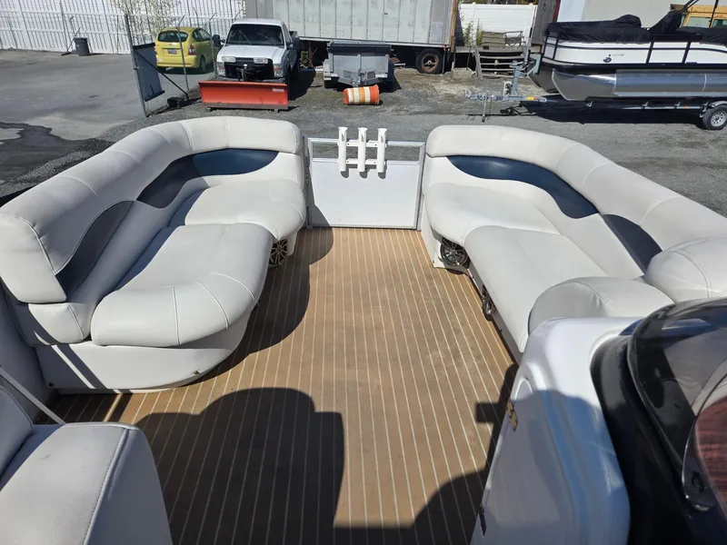 Slide: The Image of 2016 AquaPatio 240 CB boat interior with spacious seating and wood-style flooring. - 22