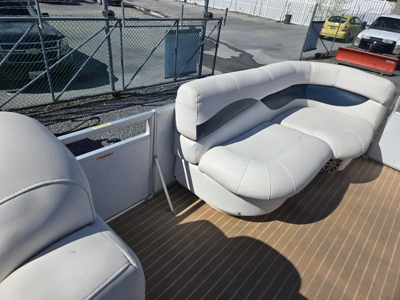 Slide: The Image of 2016 AquaPatio 240 CB boat interior with plush seating and wood-style flooring. - 23