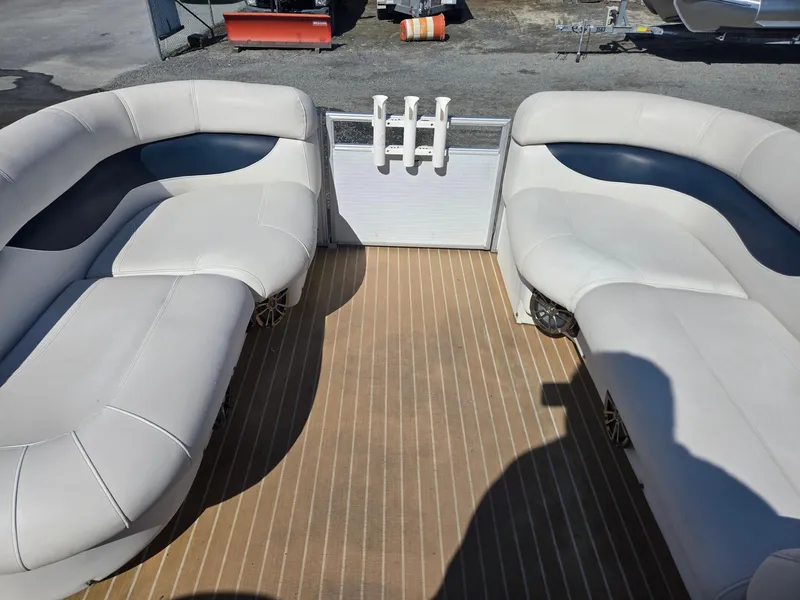 Slide: The Image of 2016 AquaPatio 240 CB boat interior with beige seating and wood-style flooring. - 24