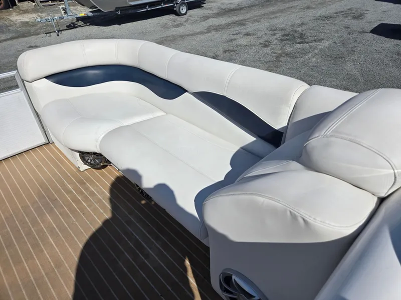 Slide: The Image of 2016 AquaPatio 240 CB boat seating with white and gray upholstery on a wooden deck. - 26