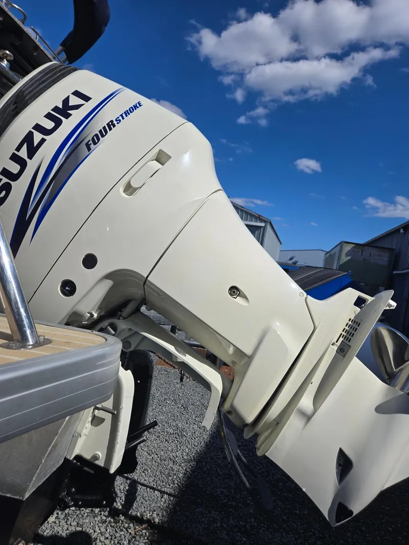 Slide: The Image of Suzuki Four Stroke engine on 2016 AquaPatio 240 CB boat under a clear blue sky. - 29