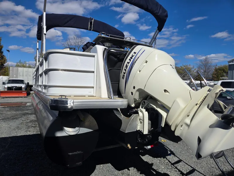 Slide: The Image of 2016 AquaPatio 240 CB pontoon boat with Suzuki outboard motor, parked outdoors. - 4
