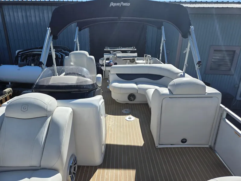 Slide: The Image of 2016 AquaPatio 240 CB boat with spacious seating and canopy, docked in a marina. - 6