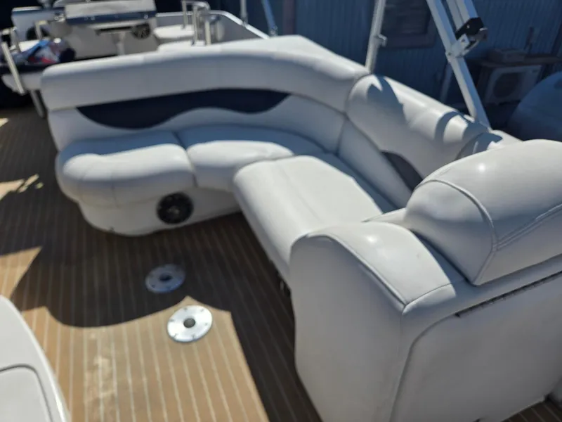 Slide: The Image of Luxurious seating on 2016 AquaPatio 240 CB boat, featuring plush white upholstery. - 9