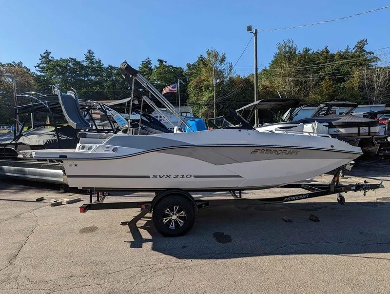 Slide: The Image of 2024 Starcraft SVX 210 IO boat on trailer, parked outdoors. - 1