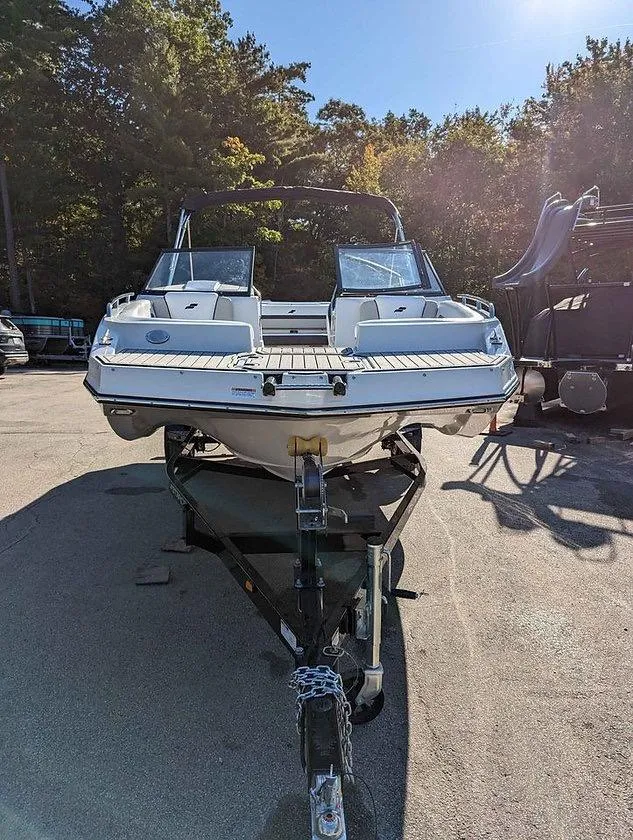 Slide: The Image of 2024 Starcraft SVX 210 IO boat on trailer, parked outdoors in sunlight. - 10